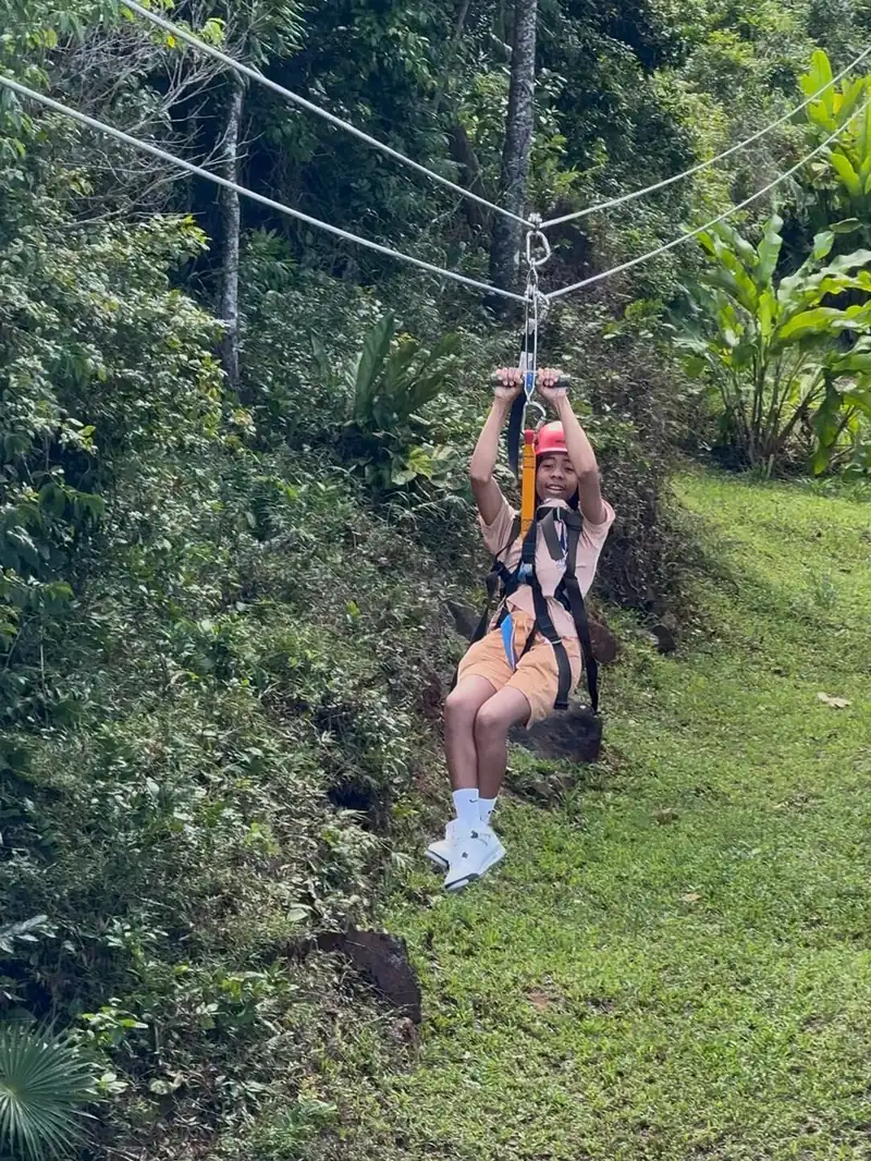 Una persona en una tirolina entre altos árboles de la selva