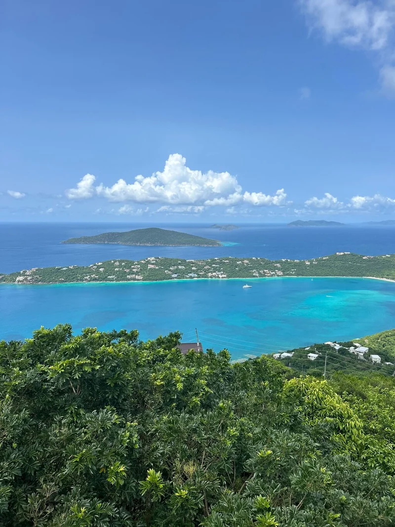 Colinas verdes que bajan hasta una bahía azul con islas en el horizonte
